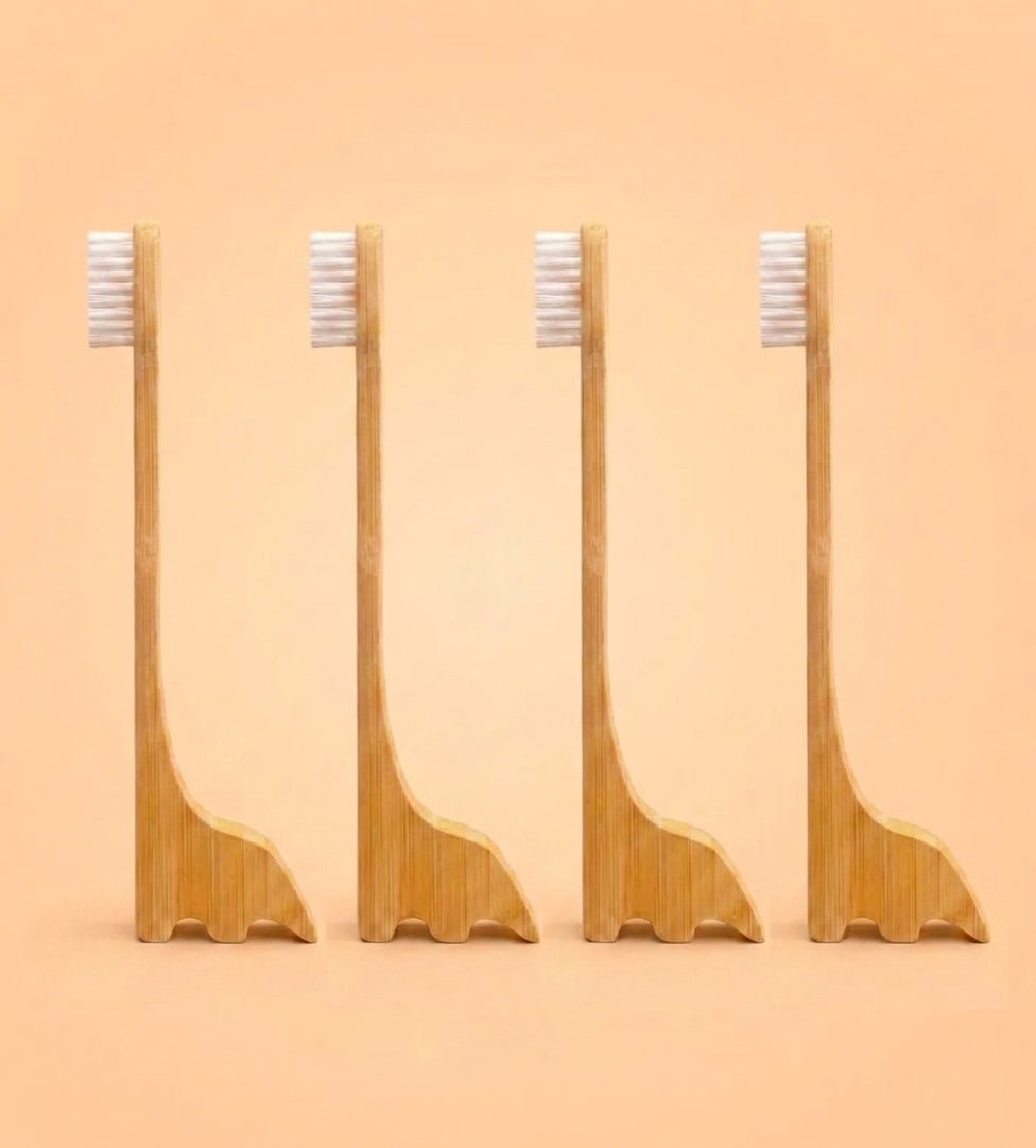Four bamboo toothbrush stands with white bristles, arranged in a row against a solid peach background by Bamboo Switch