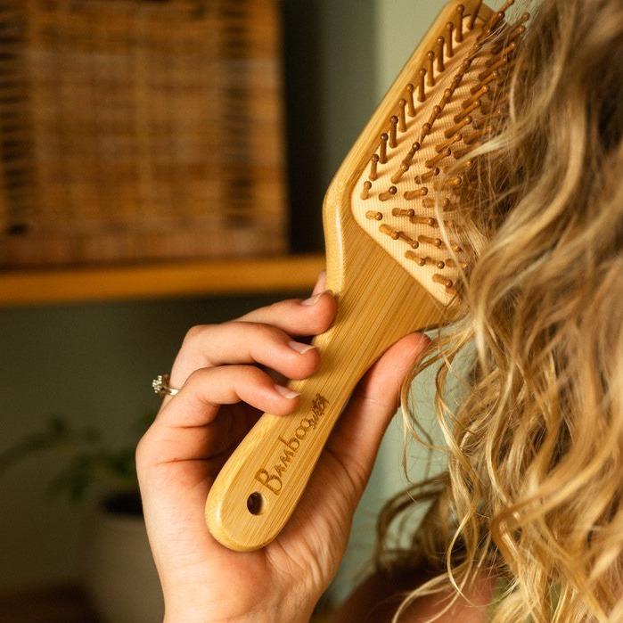 Bamboo Hair Brush in Hand brushing Hair