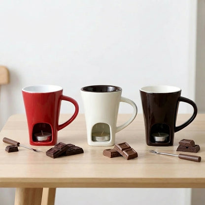 Three mugs with built-in chocolate holders on a wooden table with chocolate pieces and utensils.