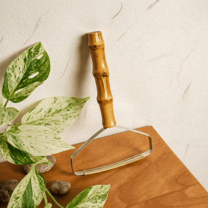 Bamboo Lint Remover laid on a table next to some foliage | Bamboo Switch