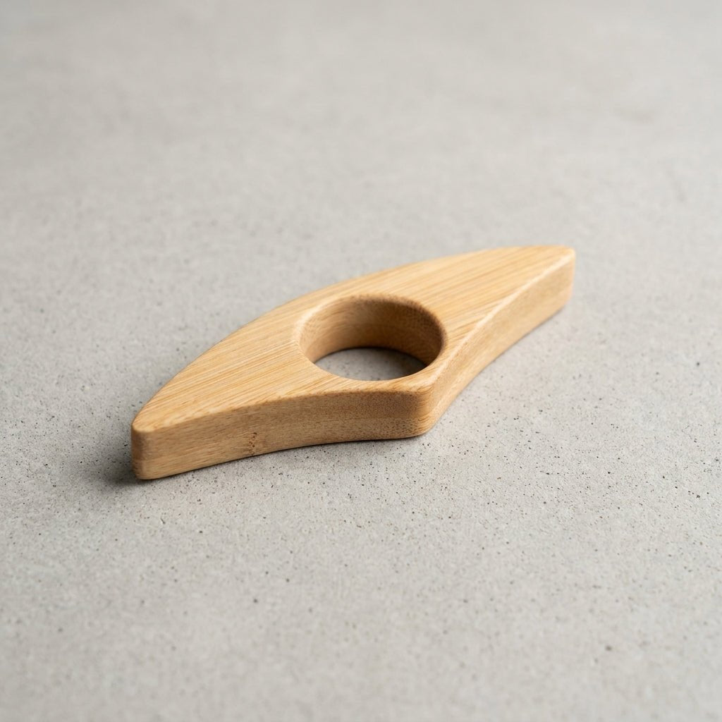 A bamboo ring pull handle with a smooth grain, photographed on a textured gray concrete surface by Bamboo Switch