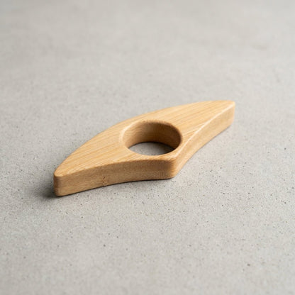 A bamboo ring pull handle with a smooth grain, photographed on a textured gray concrete surface by Bamboo Switch