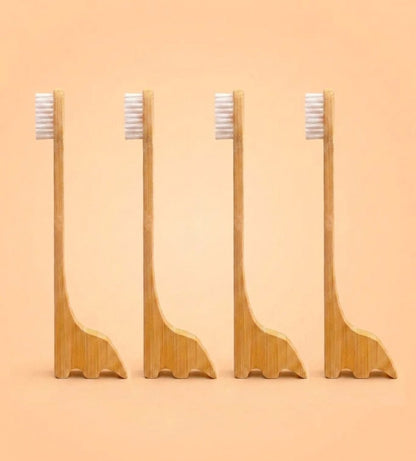 Four bamboo toothbrush stands with white bristles, arranged in a row against a solid peach background by Bamboo Switch
